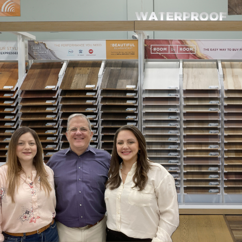 two women and man smiling in flooring store